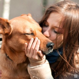 a woman kissing her dog