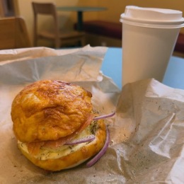 a breakfast sandwich and drink on a table