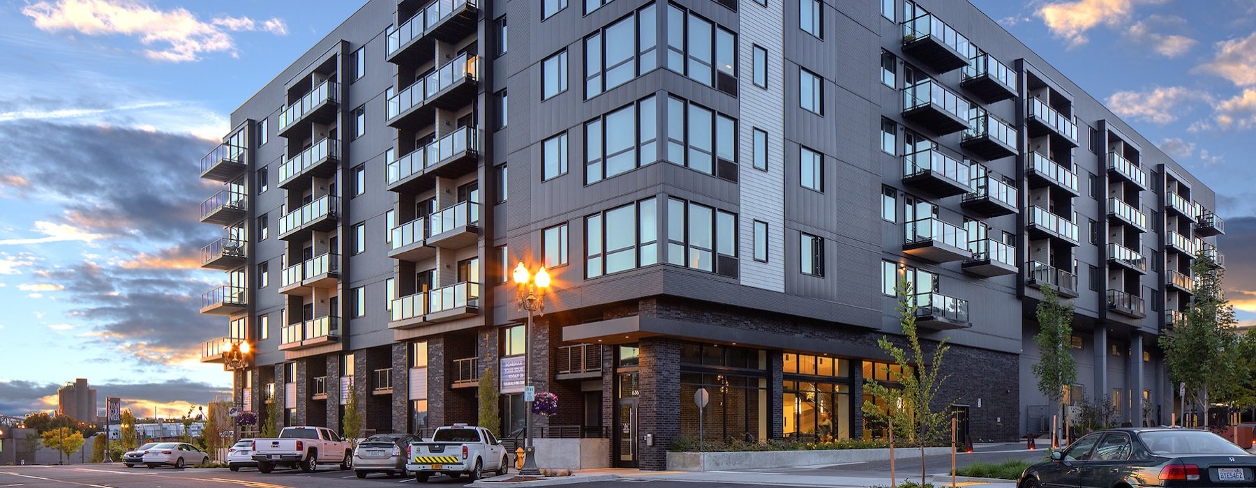 a building with balconies and cars parked in front
